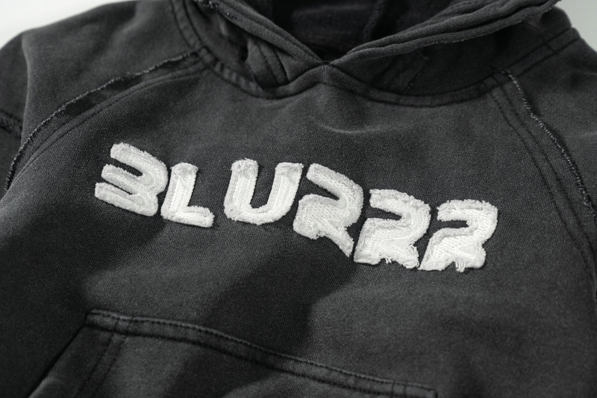 Black hoodie with 'BLURRR' text on a plain background