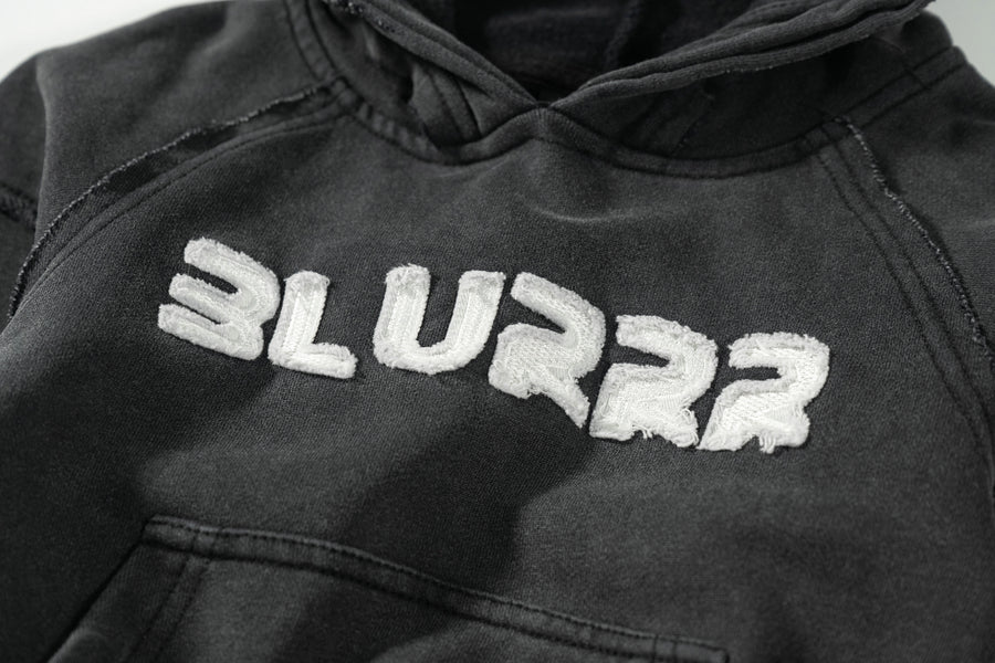 Black hoodie with 'BLURRR' text on a plain background