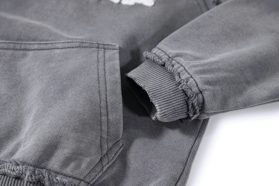 Close-up of a grey denim jacket with rolled-up sleeve on a white background