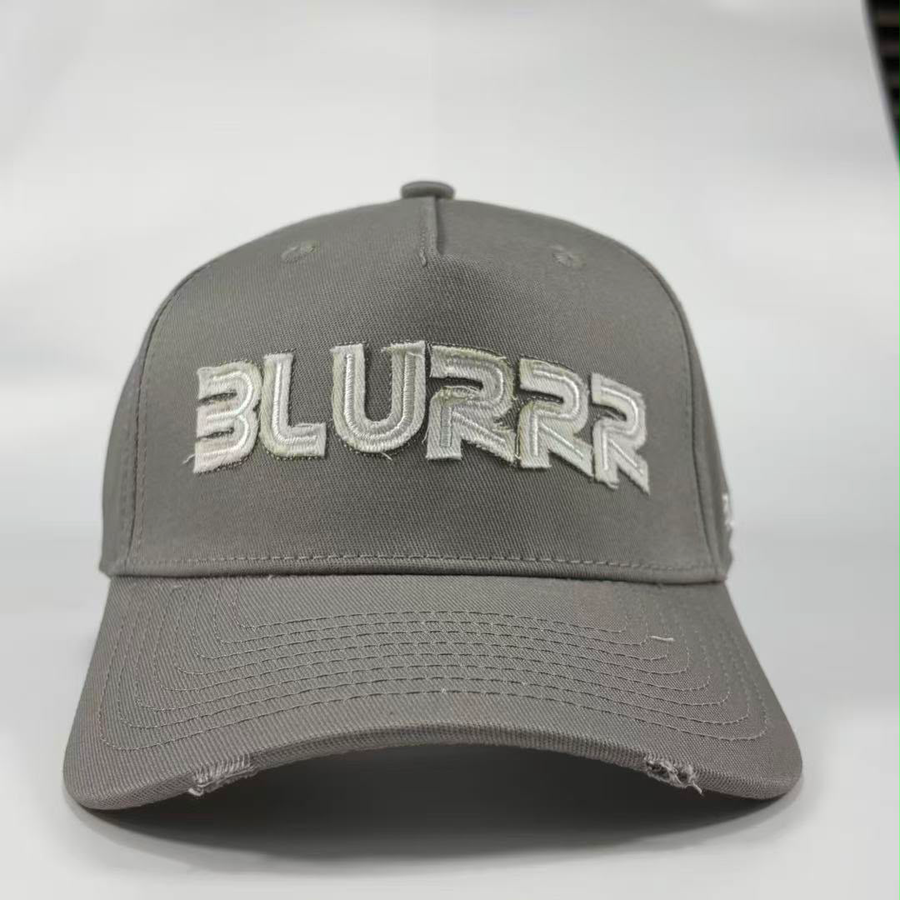 A grey baseball cap with a distressed design, featuring the word 'BLURRR' embroidered in white and grey on the front, set against a plain light grey background.