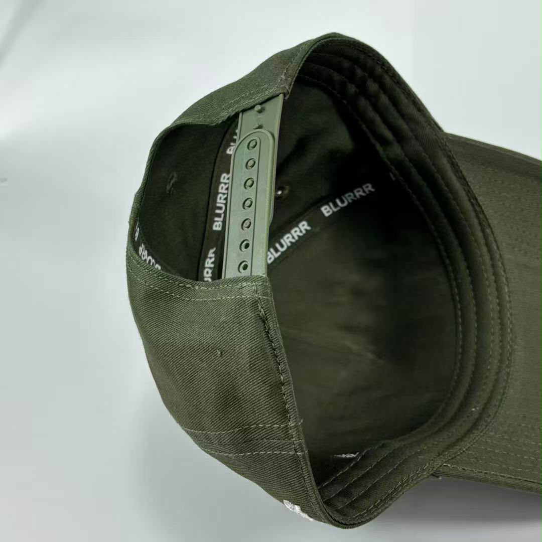 Close-up of the interior of an olive green cap, showing the adjustable inner band with printed BLURRR branding and ventilation eyelets.