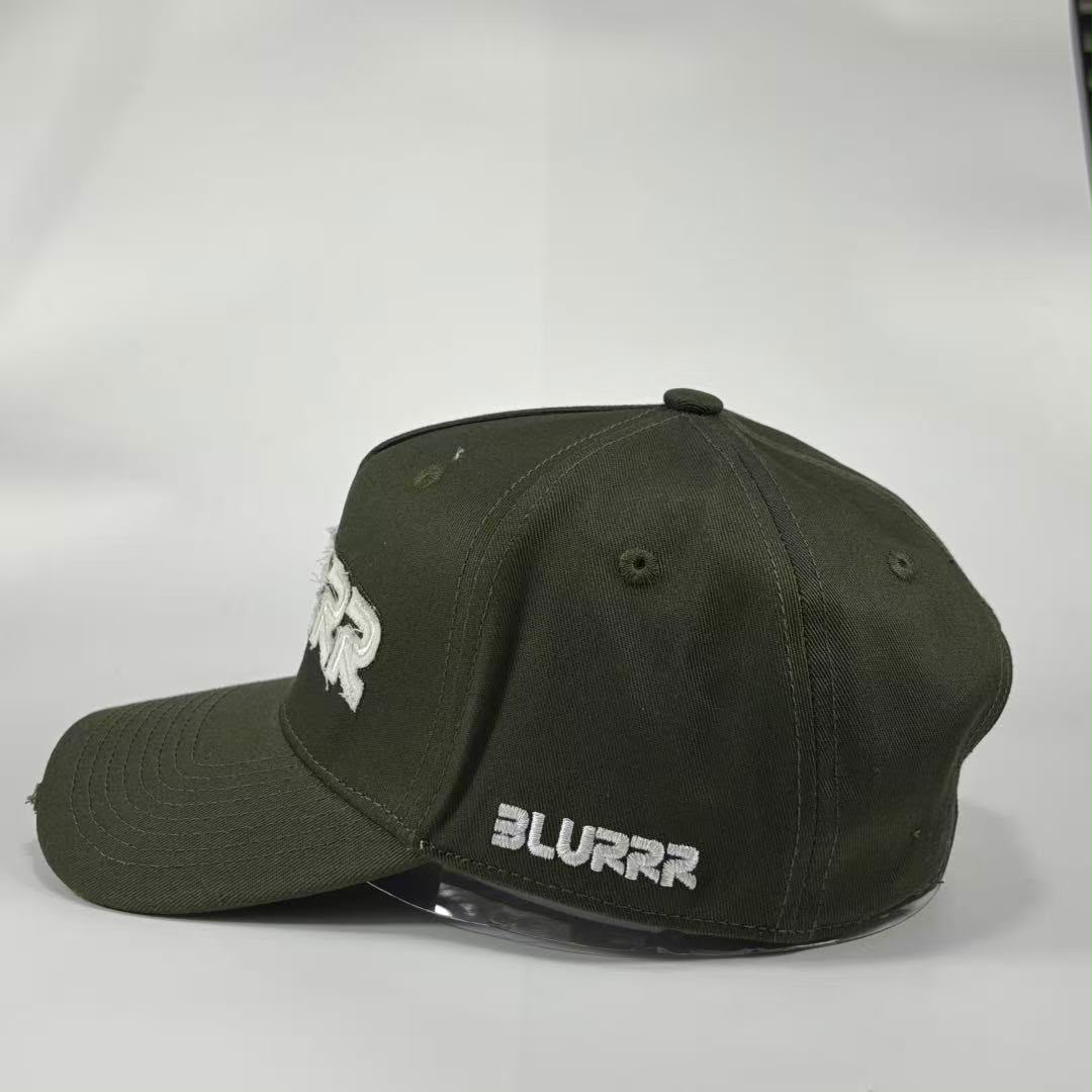 An olive green baseball cap with white embroidered text, featuring 'BLURRR' on the brim and a stylized logo on the side, set against a plain light gray background.