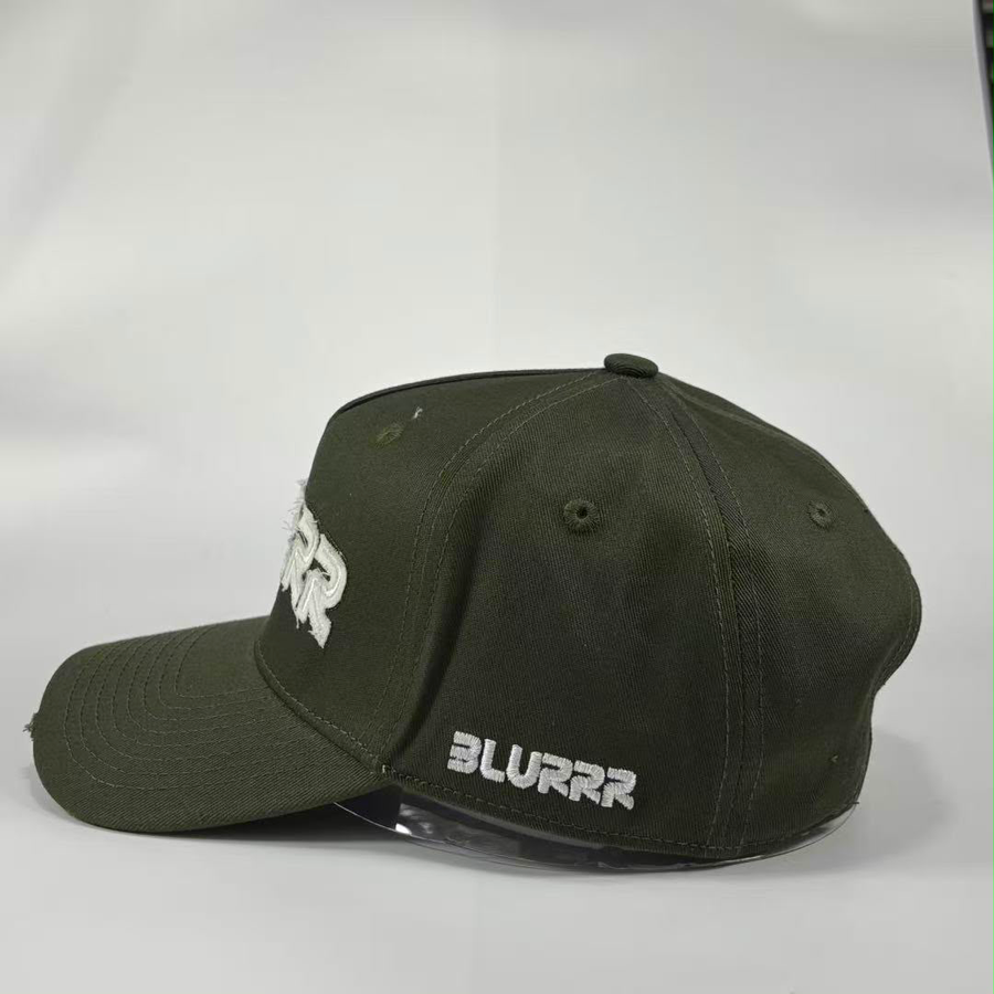 An olive green baseball cap with white embroidered text, featuring 'BLURRR' on the brim and a stylized logo on the side, set against a plain light gray background.