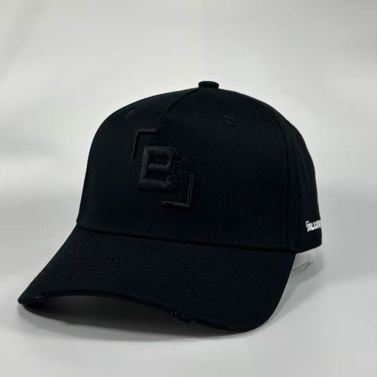 A black baseball cap with a distressed brim, featuring a black embroidered geometric 'B' logo on the front and a small white embroidered logo on the side, photographed on a light grey background.
