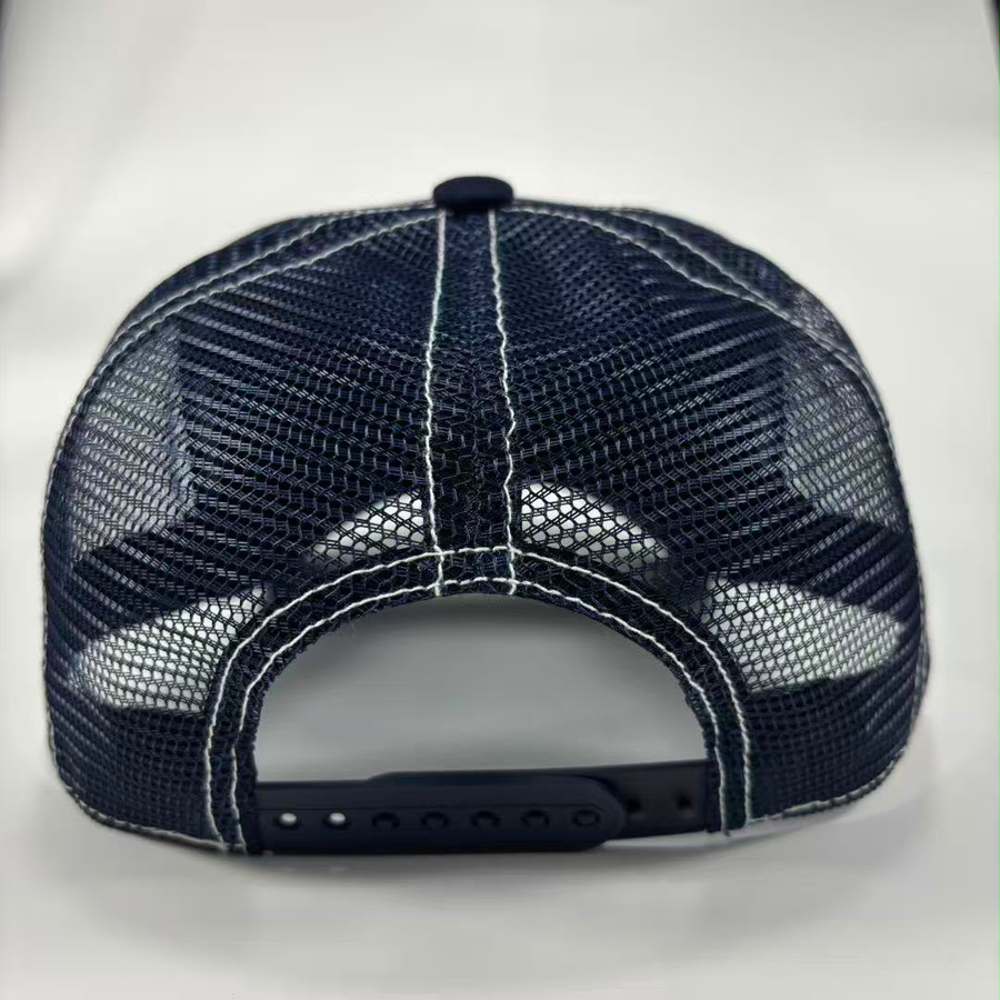 A dark navy blue trucker-style baseball cap shown from the back, featuring a mesh back with white contrast stitching and an adjustable snap closure.