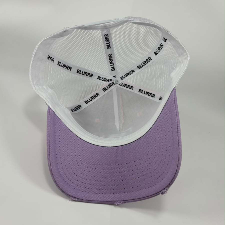 A purple and white trucker-style cap shown from a top-down angle, with a white mesh back and a purple curved brim. The inside of the crown features a white mesh band with the brand name 'BLURRR' printed repeatedly in black.