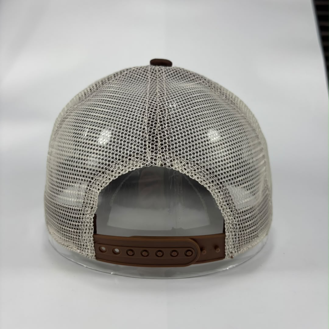 The back view of a trucker-style baseball cap featuring a beige/off-white mesh back, a brown adjustable strap, and a matching brown button on top.