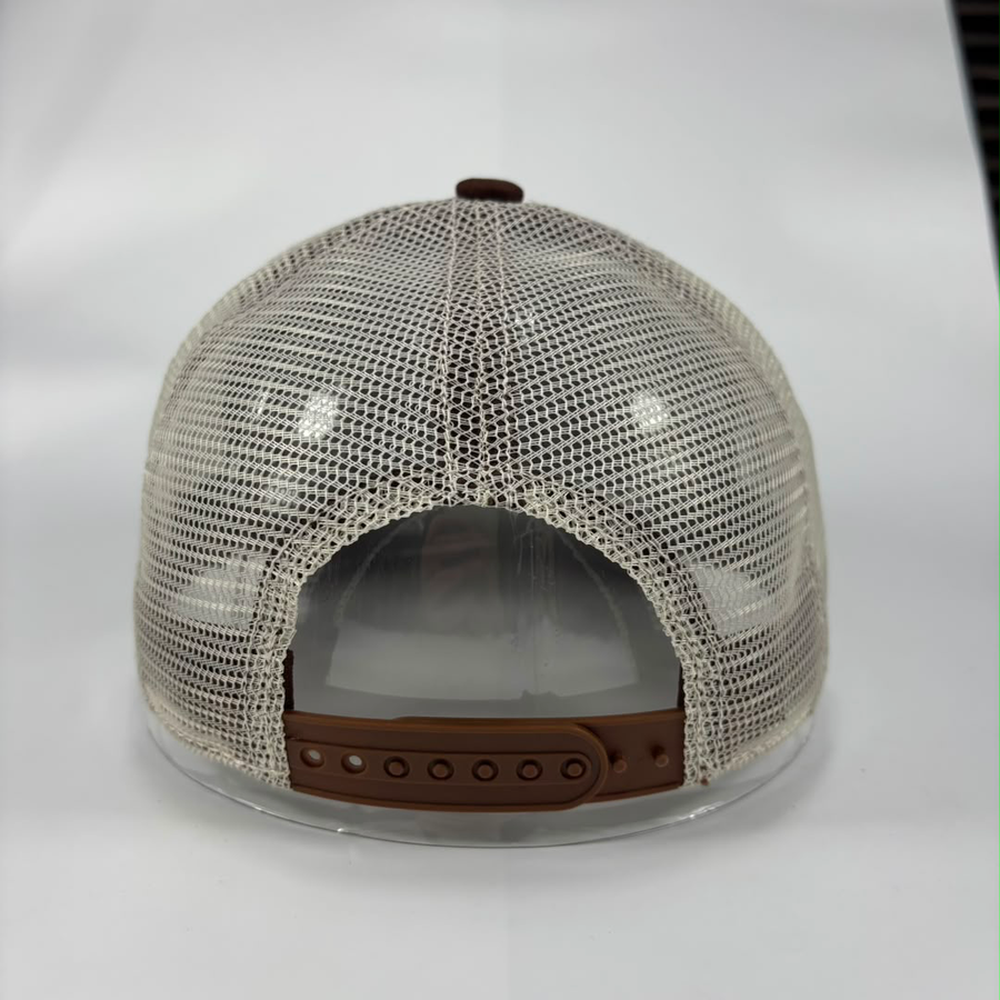 The back view of a trucker-style baseball cap featuring a beige/off-white mesh back, a brown adjustable strap, and a matching brown button on top.