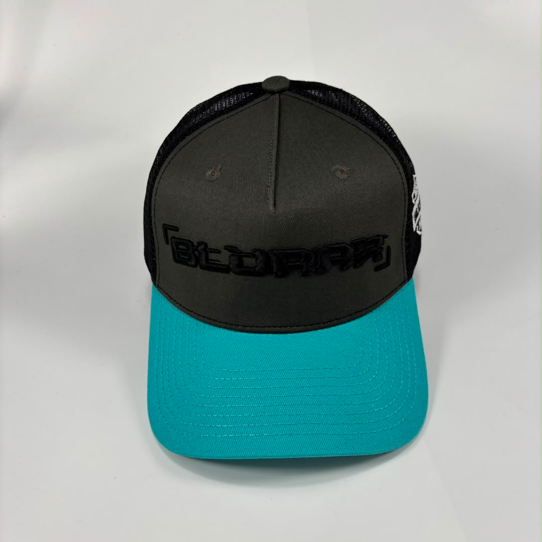 A trucker-style baseball cap with a dark gray front panel, black mesh back, and a bright turquoise curved brim. The front panel features the word 'BLURRR' in black embroidered lettering.