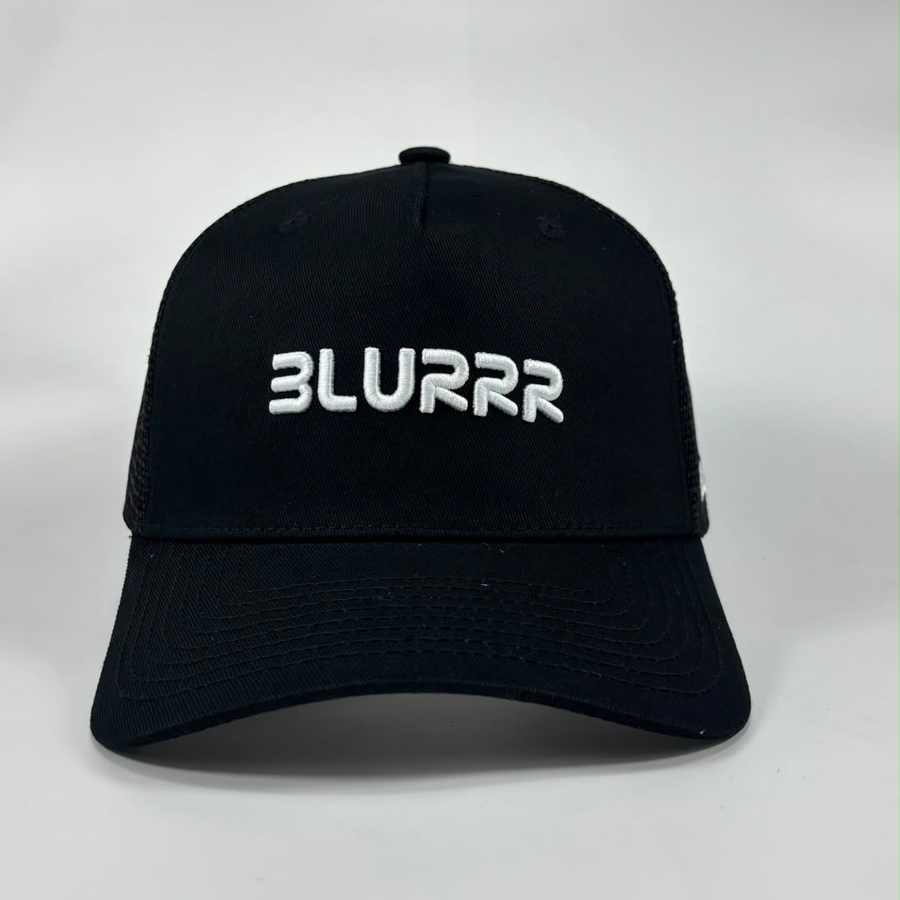 A black trucker-style baseball cap with white embroidered text reading 'BLURRR' on the front, photographed against a light grey studio background.