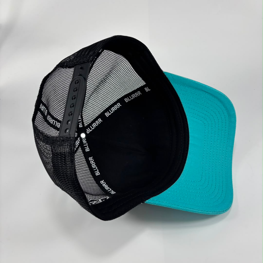 A trucker-style baseball cap with a black mesh back and a bright turquoise flat brim, shown on a light gray background. The back band is black with the brand name 'BLURRR' repeated in white.